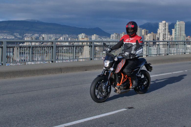 Motorcyclist riding on a waterfront road, demonstrator action shot