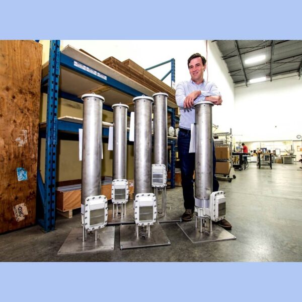 Dean Pick with KVA actuator test rigs in the Kinitics shop, feature image